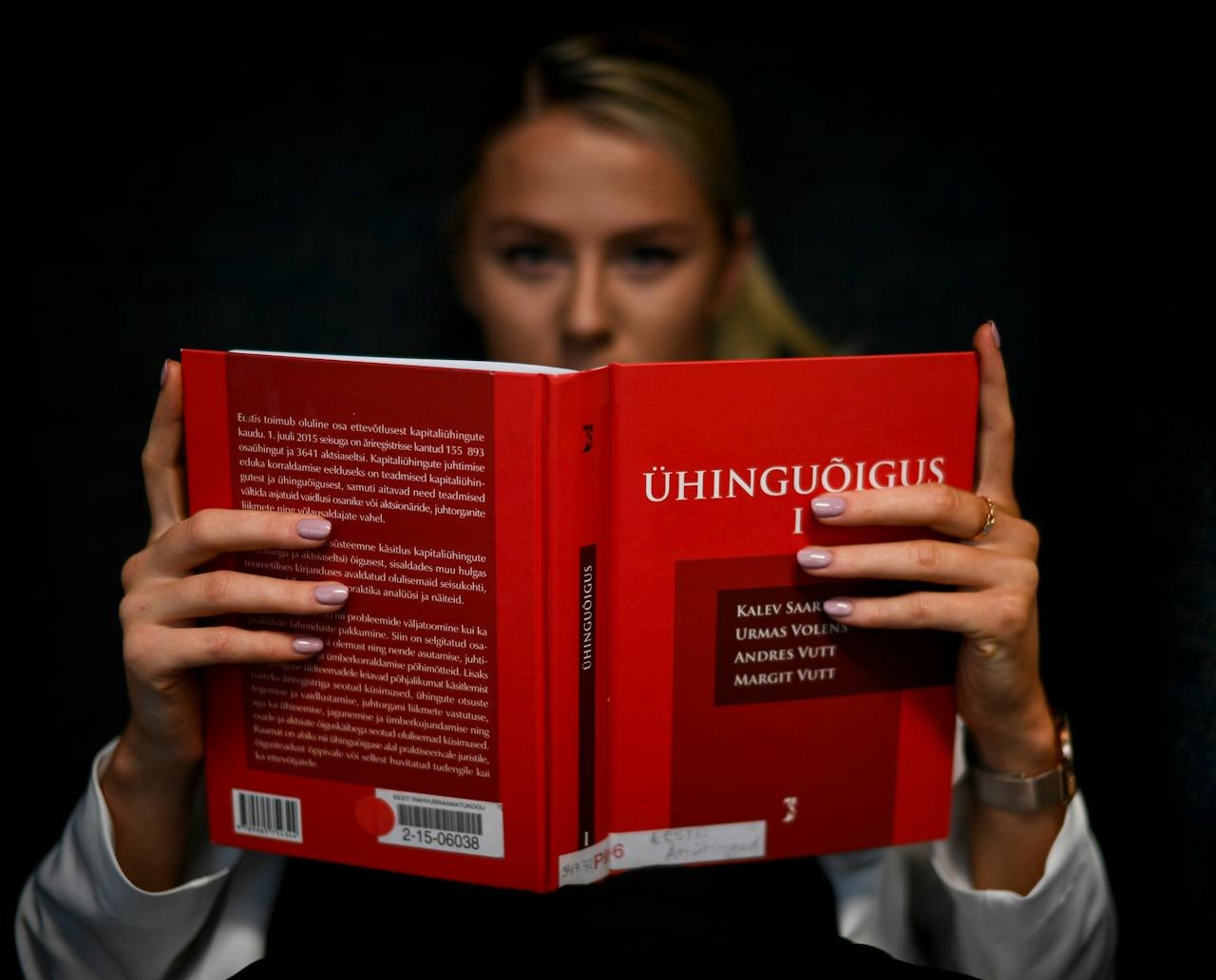 A law student intensely reading a legal textbook indoors in Tallinn, Estonia.